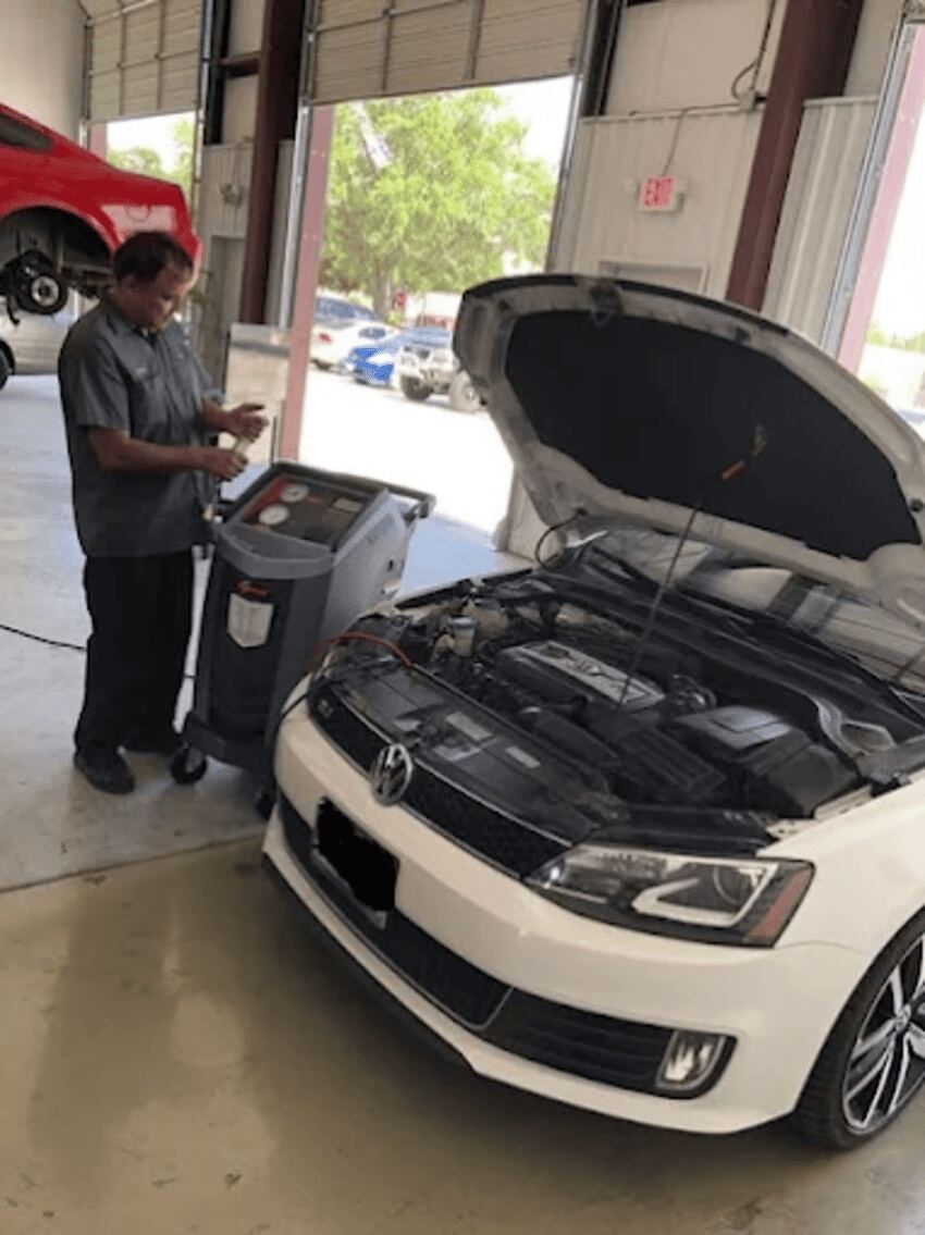Technician performing A/C service on a Volkswagen at Northwest Express Auto Care