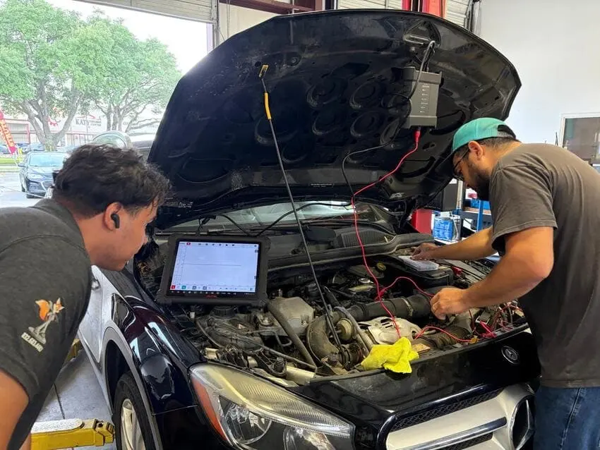 Technicians running computer diagnostics under the hood at Northwest Express Auto Care
